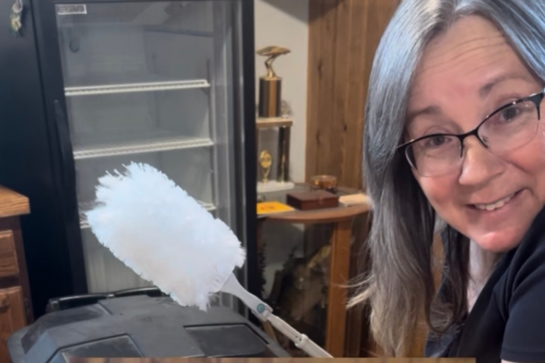 Cleo Schoenfelder holding the Amazon Basics Heavy Duty Extendable Duster Kit used to clean high windows and hard-to-reach areas in a South Dakota home.